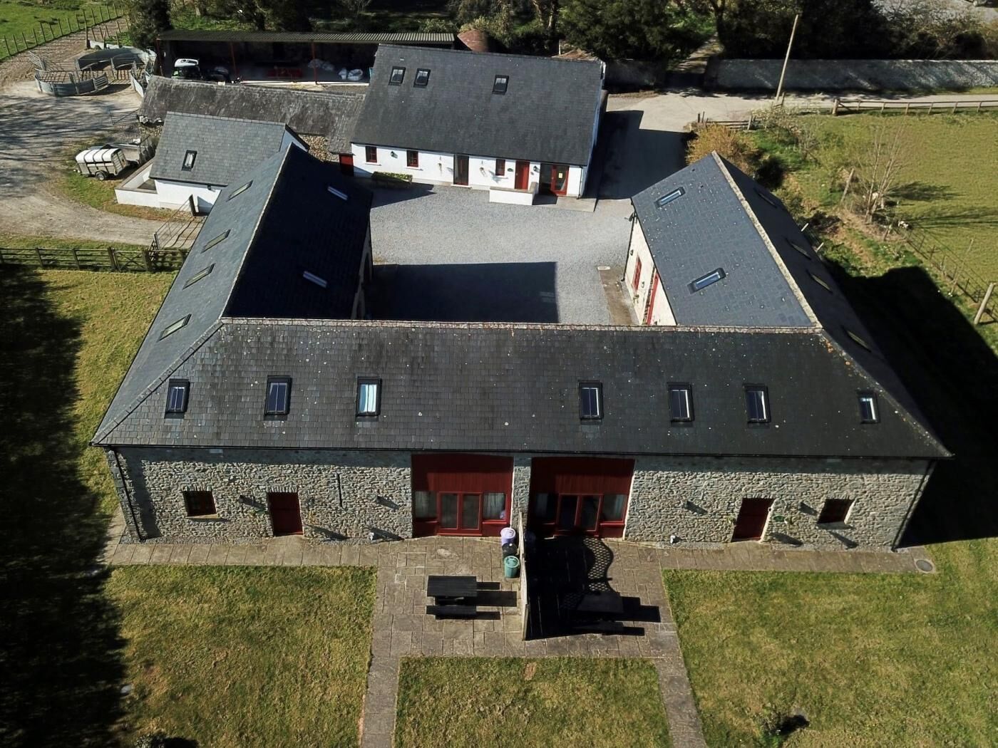 Ein großes Gebäude mit geneigtem Dach, zahlreichen Fenstern und einem zentralen Eingang.