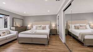 A modern bedroom with two beds, a sofa, and a large mirror. - Peaceful Tujunga Retreat Mountain Views Near Universal (Los Angeles)