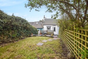 A house with a garden, a wooden fence, and a paved pathway leading to the house. - 2 Bed in Millbrook (oc-t39050) (Millbrook)