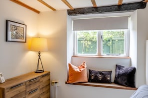A room with a window seat, a lamp, a wooden dresser, and a framed picture on the wall. - 3 Bed in Henstridge (oc-s40246) (Henstridge)