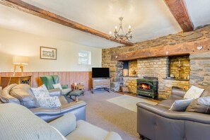 A cozy living room with leather sofas, a stone fireplace, and a television. - 4 Bed in Builth Wells (oc-t38238) (Treflys)