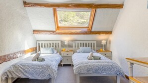 A room with two beds, a skylight, and a small table. - 4 Bed in Builth Wells (oc-t38238) (Treflys)