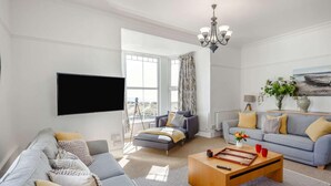 A modern living room with a sofa, a coffee table, and a television. - 8 Bed in Barmouth (oc-89784) (Barmouth)
