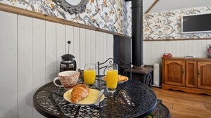 Ein Esstisch mit einem Croissant, einer Tasse und einem Glas Orangensaft.