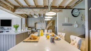 A modern kitchen with a central island, pendant lighting, and a rustic ceiling. - 4 Bed in Liddington (oc-p38233) (Liddington)