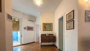 Un couloir doté d’un plancher en bois, d’une armoire en bois et de tableaux encadrés accrochés aux murs.