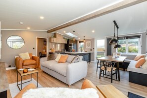 A modern living room with a sofa, armchair, and dining table.