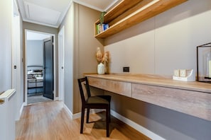 A modern kitchen with a wooden countertop, a built-in shelf, and a chair.