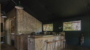 A rustic kitchen with wooden cabinetry, a bar area with stools, and a window providing natural light. - 3 Bed in Hintlesham (oc-r39060) (Hintlesham)