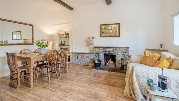 Ein Zimmer mit Esstisch, Stühlen, Kamin, einer Couch und einem Bett.
