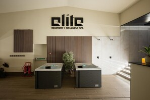 A spa reception area with a modern design, two massage tables, a fire extinguisher, a push bar, and a sign for the spa. - 4 Bed in Bishops Tawton (oc-s35786) (Bishop's Tawton)