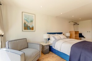 A bedroom with a bed, bedside tables, a chair, a wardrobe, and a painting on the wall. - 4 Bed in Bishops Tawton (oc-s35786) (Bishop's Tawton)