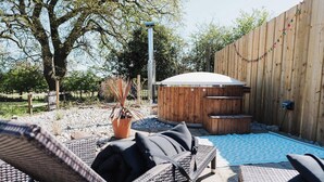 Un patio al aire libre con mobiliario de mimbre, una piscina pequeña y una terraza de madera.