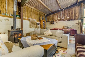 Ein gemütliches Zimmer mit Kamin, einer Couch und einem Bücherregal.