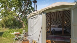 A tent with a bed, a table, and a chair outside. - 1 Bed in Bronington (oc-d39075) (Bronington)