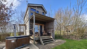 A wooden cabin with a hot tub, outdoor seating, and a staircase leading to the entrance. - 1 Bed in Earsdon (oc-l40253) (Earsdon)