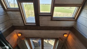 A wooden cabin with a sloped ceiling, skylights, and a view of a grassy field. - 1 Bed in Earsdon (oc-l40253) (Earsdon)