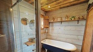 A bathroom with a wooden wall, a freestanding bathtub, and a glass shower enclosure. - 1 Bed in Earsdon (oc-l40253) (Earsdon)