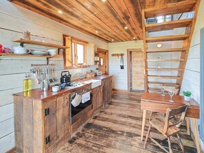 Une cuisine rustique avec des meubles en bois, un évier et un coin repas comprenant une table et des chaises.