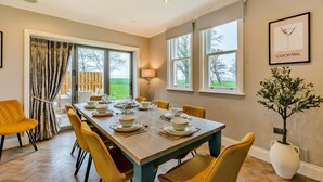 A dining room with a long table set for six, large windows, and a view of the outdoors. - 5 Bed in Weeton (oc-p39054) (Weeton-with-Preese)
