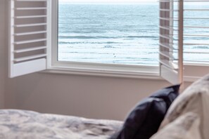 Ein Schlafzimmer mit Fenster mit Blick aufs Meer.