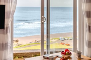 A view of the ocean through a window with a table in the foreground. - 1 Bed in Putsborough (oc-b38249) (Croyde)