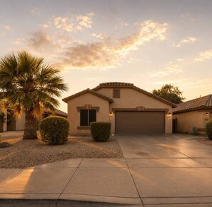 A single-story house with a garage, a palm tree, and a well-maintained lawn. - Desert Disconnect | Outdoor Cinema • Pool (Mesa)