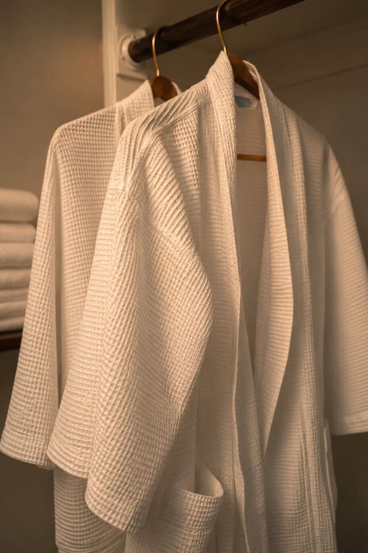 A rack with white robes hanging on it.