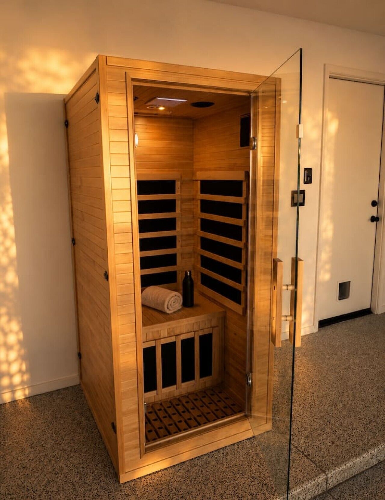 A sauna with a wooden exterior, a bench inside, and a door with a handle.