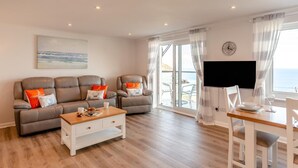Un salon comprenant un canapé, une table basse et un coin repas avec un téléviseur et une table.