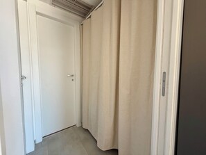 A narrow hallway with a white door and beige curtains. - Peonie 5 - Two Bedroom Apartment, Sleeps 5 (Rapallo)