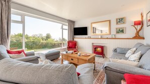 Uma sala de estar com sofá, poltrona e mesa de centro de madeira.