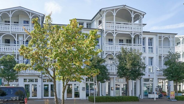 A multi-story building with a symmetrical facade, large windows, and a central entrance. - Moderne Ferienwohnung mit Balkon in Sellin (Sellin)