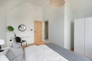 A bedroom with a bed, a desk, a chair, a wardrobe, and a mirror. - 2 Bed in Whitstable (oc-s39502) (Whitstable)