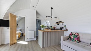 Una habitación moderna estilo loft con cocina, comedor y sala de estar.
