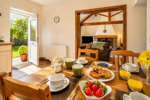 A breakfast setup with a table, chairs, and a view of the garden through the open door. - 2 Bed in Gransmoor (oc-w37884) (Gransmoor)
