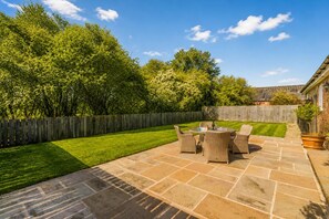 A patio with a table and chairs, surrounded by a wooden fence and a grassy lawn. - 2 Bed in Gransmoor (oc-w37884) (Gransmoor)