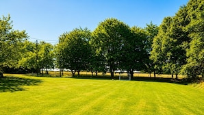 A well-maintained grassy field with a goalpost, surrounded by trees and a clear sky. - 1 Bed in Gransmoor (oc-s37885) (Gransmoor)