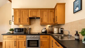 Une cuisine avec des meubles en bois, un évier en acier inoxydable, un grille-pain et un four à micro-ondes.