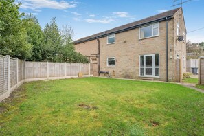 A two-story house with a brick exterior, a fenced backyard, and a satellite dish. - 3 Bed in Matlock Moor (oc-m36349) (Matlock)