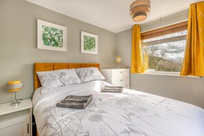 A bedroom with a bed, bedside tables, a nightstand, a lamp, a window with curtains, and two wall-mounted pictures. - 3 Bed in Matlock Moor (oc-m36349) (Matlock)