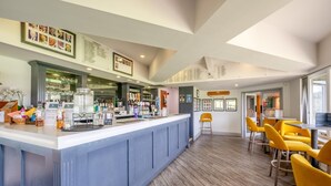 A bar area with a counter, bar stools, and framed pictures on the walls. - 3 Bed in Matlock Moor (oc-m36349) (Matlock)