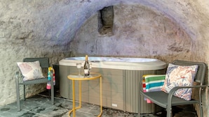 Ein Whirlpool mit zwei Stühlen, einem kleinen Tisch und einer Flasche Champagner.