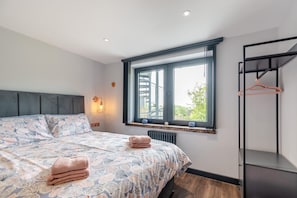A bedroom with a bed, a window, a radiator, and a wardrobe. - 1 Bed in Tenby (oc-b41401) (Tenby)