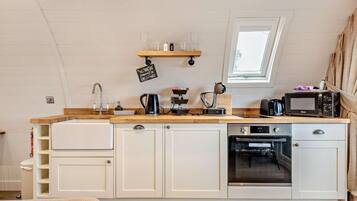 Een microgolfoven, een oven, een vaatwasser, kookgerei, borden en bestek