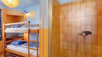 A bunk bed with a wooden frame and a shower with a handheld showerhead.