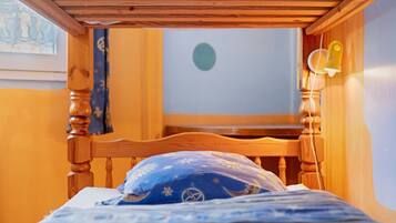Een houten bed met een blauw kussen en een muur met een ronde decoratie.