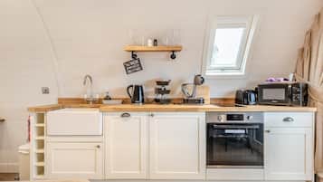 Een microgolfoven, een oven, een vaatwasser, kookgerei, borden en bestek