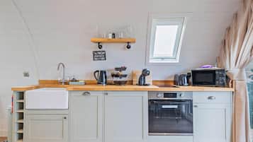 Een microgolfoven, een oven, een vaatwasser, kookgerei, borden en bestek