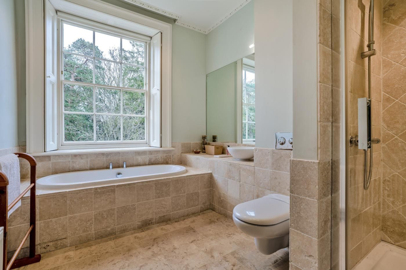 A bathroom with a bathtub, toilet, and shower area.